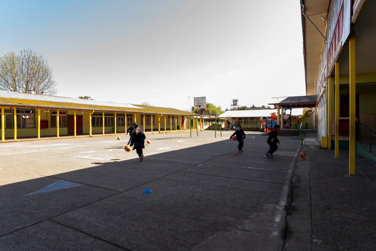 Estudiantes realizando actividades deportivas en el patio de Enseñanza Básica